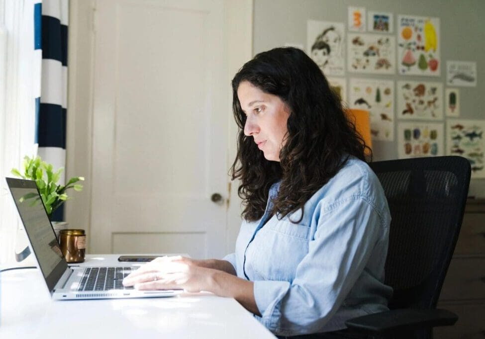 A woman sitting at her desk with a laptop.